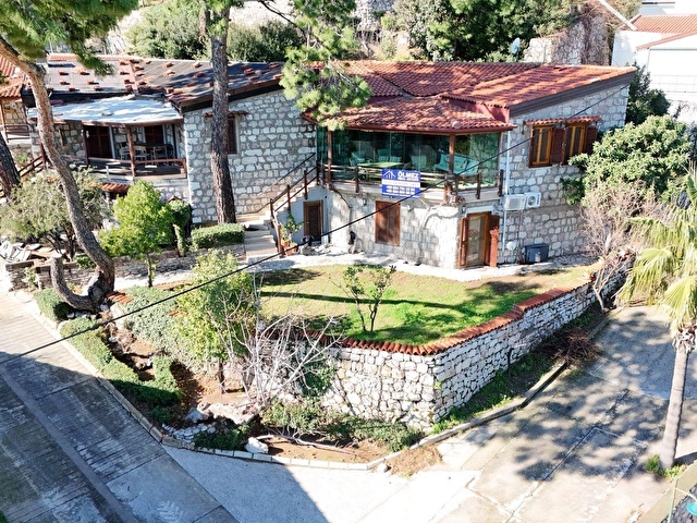 AMOS PROFESÖRLER SİTESİNDE KÖŞE KONUMDA ANTİK KENT, DENİZ VE DOĞA MANZARALI SATILIK TAŞ EV.