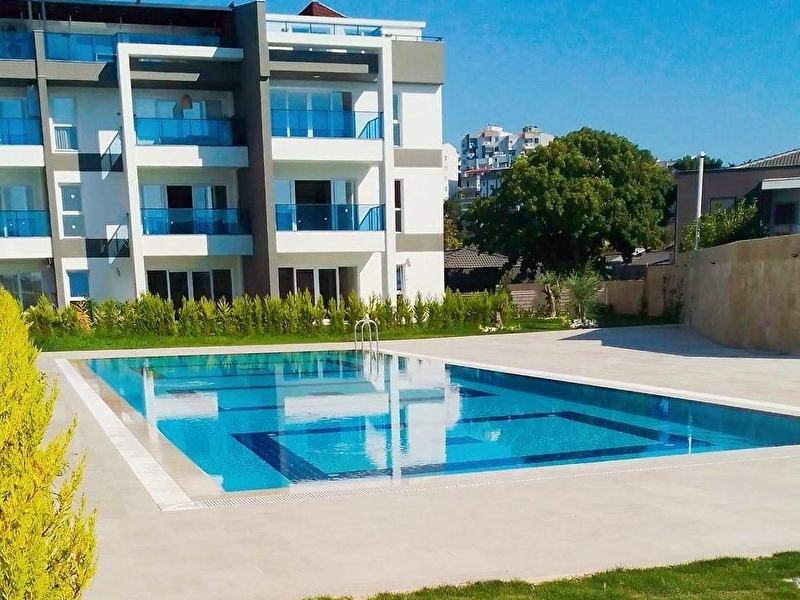 Kuşadasi kadinlar deni̇zi̇nde satilik güvenli̇kli̇ kapali garajli doğalgazli 1+1 dai̇re